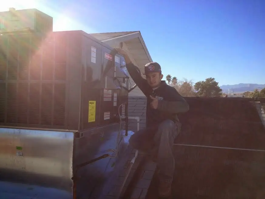 HVAC technician performing AC Tune-Up on a rooftop unit in Barrington